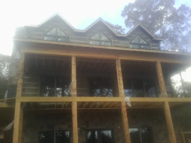 Dormers and porch framing on a large log home under construction — Roof Coating work by our crew in Oreland