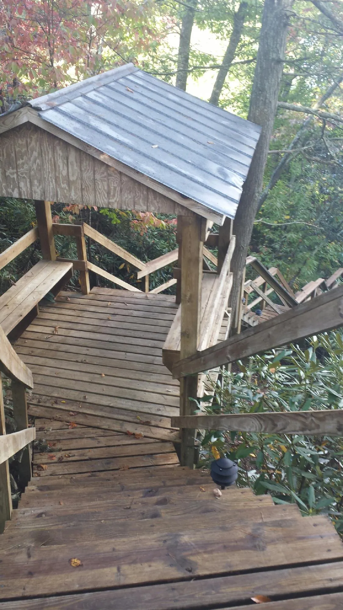 Metal roofed shelter over wooden steps on a wooded walkway — Skylight Repair & Installation work by our crew in Oreland