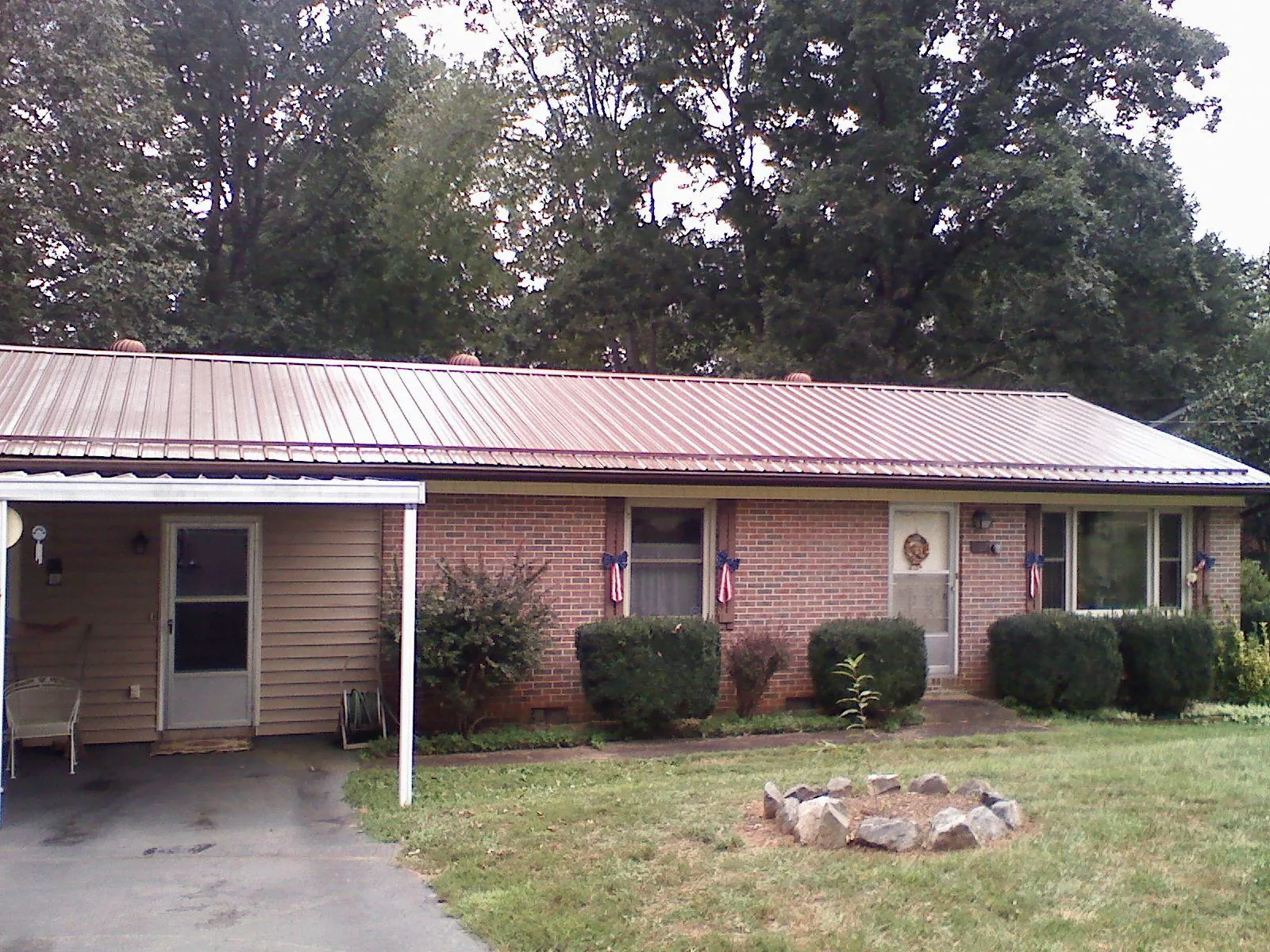 Bronze metal roof and carport on a brick ranch home — Roof Repair work by our crew in Oreland